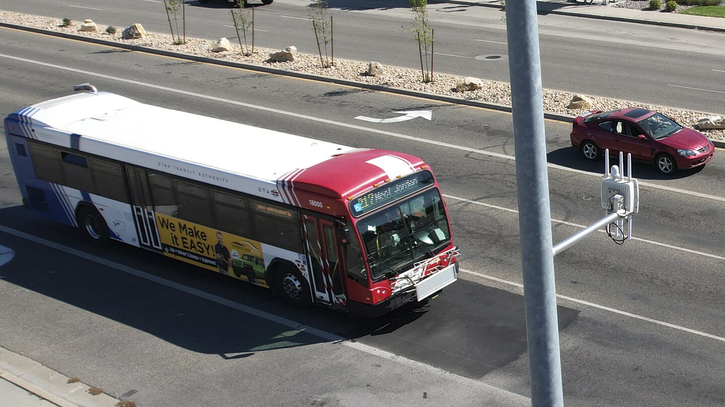 A commuter bus equipped with a radio transmitter approaches a connected traffic light on Redwood Road in Salt Lake City, part of an effort to improve 