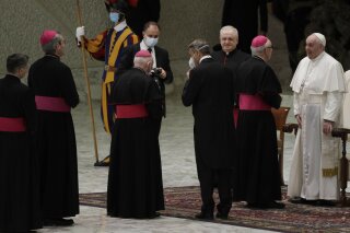 El papa Francisco, derecha, saluda a obispos al cabo de su audiencia general semanal en el Aula Pablo VI del Vaticano, 21 de octubre de 2020. (AP Foto/Gregorio Borgia)