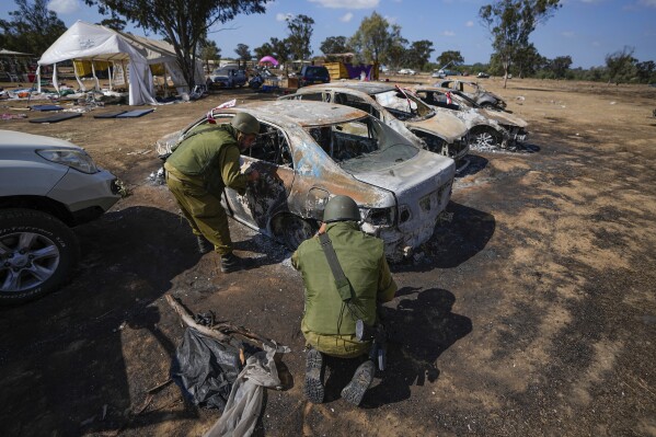 Israeli soldiers inspect the site of a music festival near the border with the Gaza Strip in southern Israel, Friday. Oct. 13, 2023. At least 260 Israeli festival-goers were killed during the attack by Hamas gunmen last Saturday. (AP Photo/Ariel Schalit)