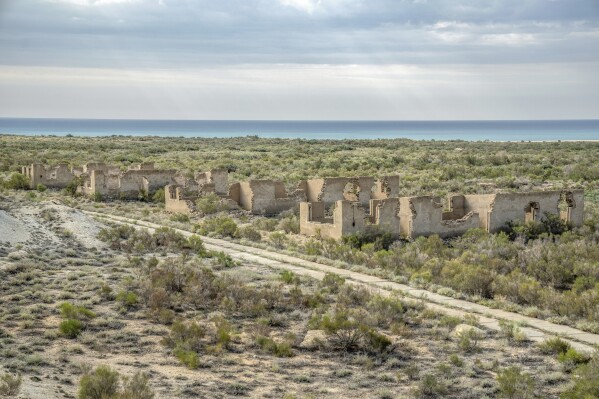 A former military base that was destroyed and evacuated after the drying up of the Aral Sea is visible in the former Aral Sea seabed Uzbekistan, Sunday, June 25, 2023. (AP Photo/Ebrahim Noroozi)