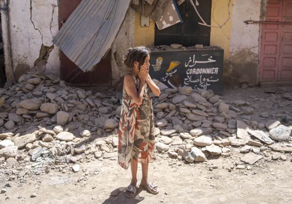 A child reacts after inspecting the damage caused by the earthquake, in her town of Amizmiz, near Marrakech, Morocco, Sunday, Sept. 10, 2023. (AP Photo/Mosa'ab Elshamy)