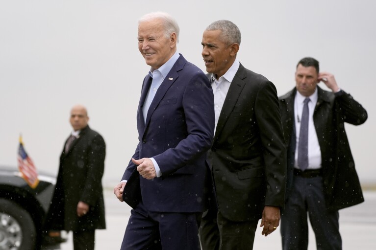 President Joe Biden, left, and former President Barack Obama arrive at John F. Kennedy International Airport, Thursday, March 28, 2024, in New York. (AP Photo/Alex Brandon)