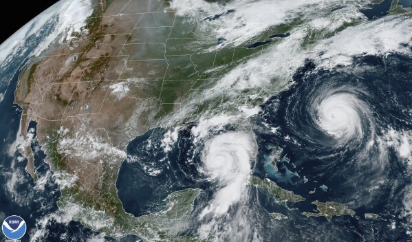 This Tuesday, Aug. 29, 2023, 1:31 p.m. EDT satellite image provided by the National Oceanic and Atmospheric Administration shows Hurricane Idalia, center, approaching Florida's Gulf Coast, and Hurricane Franklin, right, as it moves along the East coast of the United States, southwest of Bermuda. (NOAA via AP)