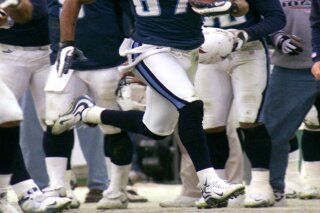 FILE - In this Jan. 8, 2000, file photo, Tennessee Titans wide receiver Kevin Dyson (87) returns a kickoff for a touchdown in the fourth quarter of an AFC wild card game against the Buffalo Bills, in Nashville, Tenn. Looking on from the sideline is Titans quarterback Steve McNair (9), left foreground. Dyson sped 75 yards down the left sideline with a lateral from Frank Wycheck on a kickoff for the winning touchdown with 3 seconds remaining, lifting the Tennessee Titans to a 22-16 playoff victory over the stunned Buffalo Bills. (AP Photo/Wade Payne, File)