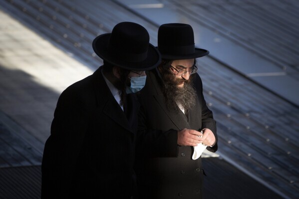 FILE - In this Thursday, Feb. 4, 2021 file photo, two ultra-Orthodox Jewish men walk in Antwerp, Belgium. Antisemitism is on the rise in Belgium since the Hamas attack against Israel that triggered a war in Gaza. According to the latest figures released Thursday by an independent body fighting discrimination, 91 reports related to the Israel-Hamas conflict were received between Oct. 7 and Dec. 7 last year. M (AP Photo/Virginia Mayo, File)