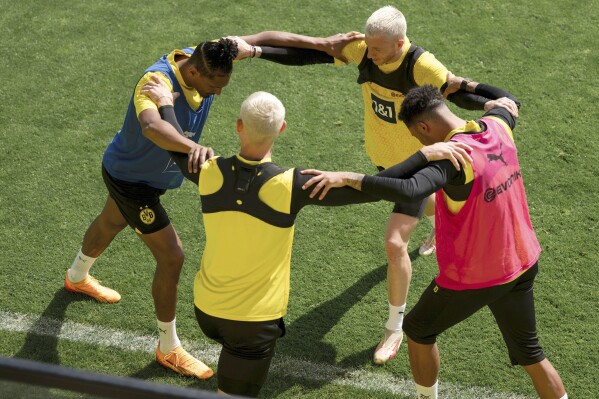From left; Borussia Dortmund's Sebastian Haller, Julian Ryerson, Marco Reus, and Jadon Sancho stretch during a team training session in Cologne, Germany, Tuesday, May 28, 2024, ahead of their Champions League final against Real Madrid in London on Saturday. (Marius Becker/dpa via AP)