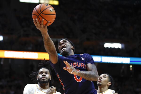 Auburn guard K.D. Johnson (0) shoots past Tennessee guards Zakai Zeigler, right, and Jahmai Mashack, left, during the second half of an NCAA college basketball game Saturday, Feb. 4, 2023, in Knoxville, Tenn. (AP Photo/Wade Payne)