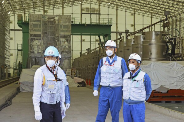 Japanese Prime Minister Fumio Kishida, left, along with Tomoaki Kobayakawa, president of Tokyo Electric Power Co. (TEPCO), second right, and Yoshimitsu Kobayashi, chairman of TEPCO, visits a facility to treat radioactive wastewater at the tsunami-wrecked Fukushima Daiichi nuclear power plant in Okuma town, northeastern Japan, Sunday, Aug. 20, 2023. Kishida made a brief visit to the power plant on Sunday to highlight the safety of an impending release of treated radioactive wastewater into the Pacific Ocean, a divisive plan that his government wants to start soon despite protests at home and abroad. (Kyodo News via AP)