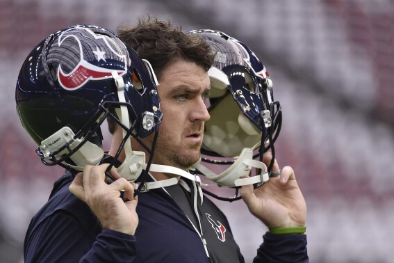 FILE - A Houston Texans staff member tests the helmet radio system before the first half of an AFC Wild Card NFL game between the Houston Texans and the Oakland Raiders, Saturday, Jan. 7, 2017, in Houston. Following a sign-stealing scandal that rocked the sport and hung over Michigan's championship run in 2023, the NCAA's football oversight committee approved Friday, April 19, 2024, the use of coach-to-player helmet communications in games for the 2024 season. The football rules committee last month made a recommendation to allow — but not require — teams at the highest tier of Division I to use radio technology similar to what NFL teams use. (AP Photo/Eric Christian Smith, File)