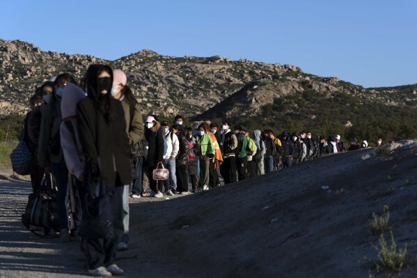 FILE - Chinese migrants wait to be processed after crossing the border with Mexico on May 8, 2024, near Jacumba Hot Springs, Calif. Arrests for illegally crossing the border from Mexico plunged 29% in June to the lowest month of Joe Biden's presidency, according to figures released Monday, July 15, 2024, that provide another window on the impact of a new rule to temporarily suspend asylum. (AP Photo/Ryan Sun,File)