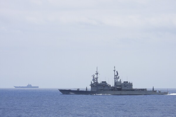In this photo released by the Taiwan Ministry of National Defense, Taiwanese navy ship Keelung, foreground, a U.S. made Kidd Class destroyer, monitors the Chinese aircraft carrier Shandong, background, near the Taiwanese waters in September 2023. On Monday, Sept. 11, 2023, China sailed its own naval formation led by the aircraft carrier Shandong about 70 miles (110 kilometers) southeast of Taiwan. The vessel was expected to conduct drills simulating aircraft, submarine, warship and land attacks, according to Chinese state media. (Taiwan Ministry of National Defense via AP)