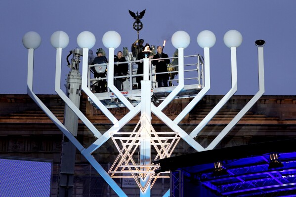 German Chancellor Olaf Scholz, right, and Rabbi Yehuda Teichtal attend the ceremony to light the first candle of Hanukkah menorah at Brandenburg Gate in Berlin, Germany, Thursday, Dec. 7, 2023. (APPhoto/Markus Schreiber)