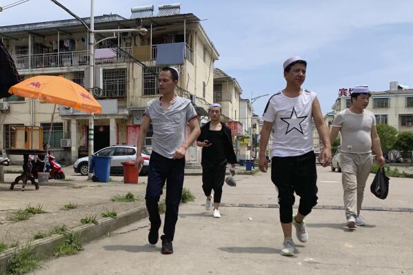 In this June 5, 2019, photo, residents of the Hui Muslim ethnic minority walk in a neighborhood near an OFILM factory in Nanchang in eastern China's Jiangxi province. The Associated Press has found that OFILM, a supplier of major multinational companies, employs Uighurs, an ethnic Turkic minority, under highly restrictive conditions, including not letting them leave the factory compound without a chaperone, worship, or wear headscarves. (AP Photo/Ng Han Guan)