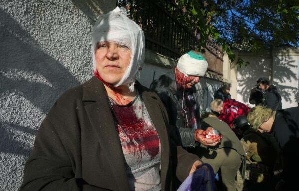 People receive medical treatment at the scene of Russian shelling, in Kyiv, Ukraine, Monday, Oct. 10, 2022. The Russian missiles that rained down Monday on cities across Ukraine, bringing fear and destruction to areas that had seen months of relative calm, are an escalation in Moscow's war against its neighbor. But military analysts say it’s far from clear whether the strikes mark a turning point in a war that has killed thousands of Ukrainians and sent millions fleeing from their homes. (AP Photo/Efrem Lukatsky)