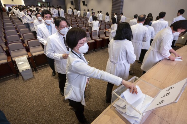 Medical professors queue to submit their resignations during a meeting at Korea University in Seoul, South Korea, Monday, March 25, 2024. Senior doctors at dozens of hospitals in South Korea planned to submit their resignations Monday in support of medical interns and residents who have been on a strike for five weeks over the government’s push to sharply increase medical school admissions, their leader said.(Yoon Dong-jin/Yonhap via AP)