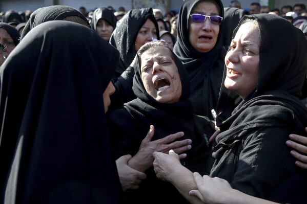 FILE - Families of victims of Saturday's terror attack on a military parade in the southwestern city of Ahvaz, that killed 25 people mourn at a mass funeral ceremony, in Ahvaz, Iran, Monday Sept. 24, 2018. Three members of an Iranian separatist group convicted of promoting terror in Iran and gathering information for an unnamed Saudi intelligence service, have been sentenced to jail sentences of six, seven and eight years. An appeal court on Friday, Jan. 12, 2024, also ruled they would be expelled from Denmark for good. (AP Photo/Ebrahim Noroozi, File)