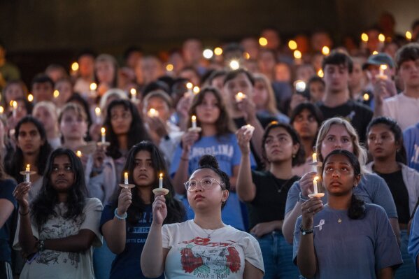 FILE - University of North Carolina-Chapel Hill students, faculty and family hold a candlelight vigil, Aug 30, 2023, in Chapel Hill, N.C., in honor of professor Zijie Yan, who was shot and killed on campus earlier that week. Two shooting 30 years apart at the University of North Carolina show how much has changed. Some alumni who remember a deadly shooting in 1995 now have children enrolled at their alma mater in Chapel Hill, where an associate professor was shot to death Aug. 28. In some ways, the era of campus shootings has come full circle though there have been vast changes in the way information spreads. (Travis Long/The News & Observer via AP, File)