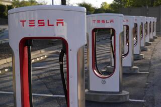 FILE - In this April 22, 2021, photo shows a Tesla Supercharger station in Buford, Ga. Tesla reports earnings on Wednesday, Jan. 25, 2023. (AP Photo/Chris Carlson)