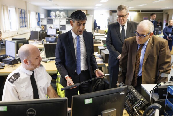Britain's Prime Minister Rishi Sunak picks up a knife while visiting Harlow Police Station during a media visit in Harlow, Essex, England, Friday Feb. 16, 2024. Knife crimes are on the rise in England and Wales, and a string of deadly attacks in recent years has stoked public anxiety and led to calls for the government to do more. (Dan Kitwood/Pool Photo via AP)