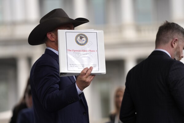 Jack Posobiec sostiene una carpeta con una portada titulada "Los expedientes de Epstein: Fase 1" en la Casa Blanca, el jueves 27 de febrero de 2025, en Washington. (Foto AP/Evan Vucci)