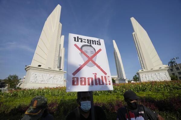 Anti-government protesters with poster which reads "Prayuth get out" gather in front of Democracy Monument in Bangkok, Thailand Tuesday, Aug. 23, 2022. Thailand’s Constitutional Court on Monday received a petition from opposition lawmakers seeking a ruling on whether Prime Minister Prayuth Chan-ocha has reached the legal limit on how long he can remain in office. (AP Photo/Sakchai Lalit)