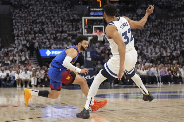 Denver Nuggets guard Jamal Murray, left, works toward the basket as Minnesota Timberwolves center Karl-Anthony Towns (32) defends during the first half of Game 3 of an NBA basketball second-round playoff series, Friday, May 10, 2024, in Minneapolis. (AP Photo/Abbie Parr)