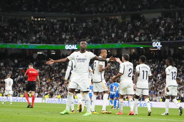 Real Madrid's Vinicius Junior, centre, celebrates after scoring his side's second goal during the Spanish La Liga soccer match between Real Madrid and Deportivo Alaves at the Santiago Bernabeu stadium in Madrid, Spain, Tuesday, May 14, 2024. (AP Photo/Jose Breton)