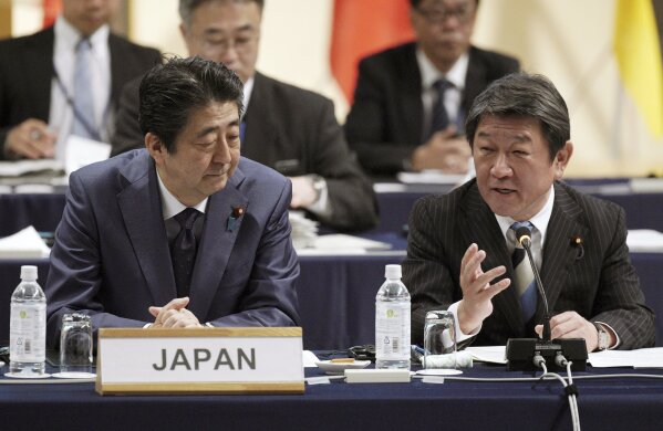 
              FILE - In this  Jan. 19, 2019, file photo, Japan's Prime Minister Shinzo Abe, left, and Minister of Economy, Trade, and Industry Toshimitsu Motegi, right, share a light moment during an opening session of the Comprehensive and Progressive Trans-Pacific Partnership (CPTPP) in Tokyo. Motegi said Friday, May 17, 2019 Washington won’t be demanding any numerical restrictions on Japanese auto exports to the U.S., speculated by media reports as a possibility. (AP Photo/Eugene Hoshiko, File)
            