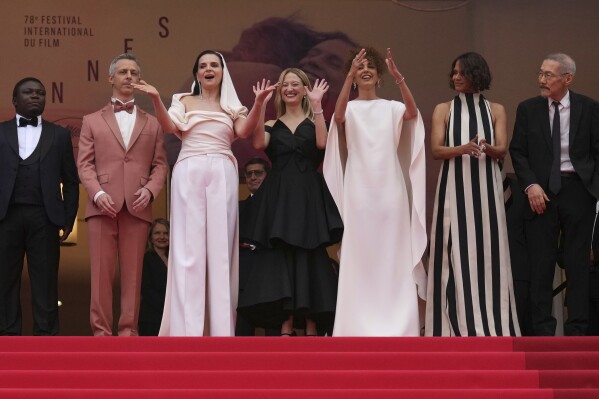 Jury president Juliette Binoche, third from left, and jury members Dieudo Hamadi, Jeremy Strong, Alba Rohrwacher, Leila Slimani, Halle Berry and Hong Sang-soo pose for photographers during the opening ceremony red carpet of the 78th international film festival, Cannes, southern France, Tuesday, May 13, 2025. (AP Photo/Natacha Pisarenko)