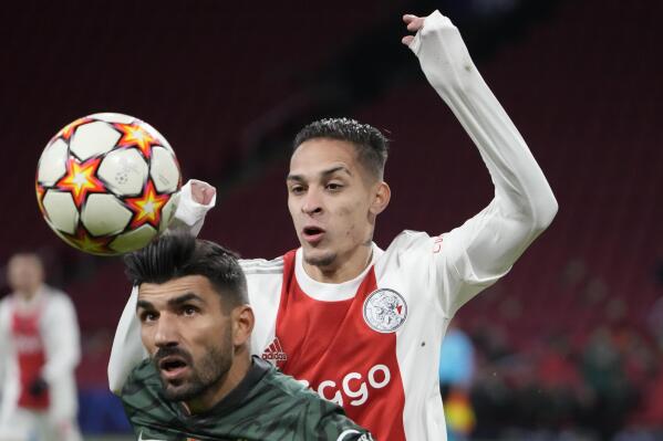 FILE - Sporting's Ricardo Esgaio, left, and Ajax's Antony jump for the ball during a Champions League group C soccer match between Ajax and Sporting CP, at the at the Johan Cruyff ArenA in Amsterdam, Netherlands, on Dec. 7, 2021. Brazil winger Antony looks set to complete a move to Manchester United for $95 million and join Lisandro Martinez in making a big-money switch from Dutch club Ajax to the English giant in this transfer window. (AP Photo/Peter Dejong, File)