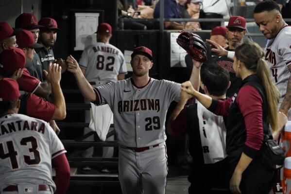 Arizona Diamondbacks starting pitcher Merrill Kelly (29) is greeted in the dugout after leaving a baseball game against the Chicago White Sox during the eighth inning Saturday, Aug. 27, 2022, in Chicago. (AP Photo/David Banks)