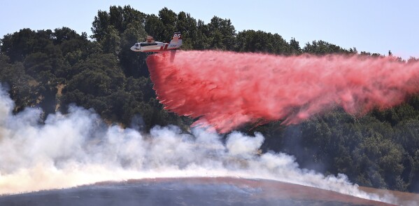 A pilot maneuvers Cal Fire tanker 85 from the Sonoma Air Attack Base for a drop on the right flank of the San Antonio Fire, west of Petaluma, Ca., Friday, June 30, 2023. California is in the middle of a heat wave during the long Fourth of July weekend. (Kent Porter/The Press Democrat via AP)