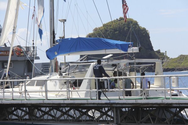 Investigators from Grenada and St. Vincent and the Grenadines stand aboard the yacht 