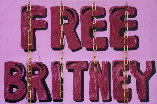 A "Free Britney" sign is decorated with chains outside a court hearing concerning pop singer Britney Spears' conservatorship at the Stanley Mosk Courhouse, Thursday, Feb. 11, 2021, in Los Angeles. (AP Photo/Chris Pizzello)