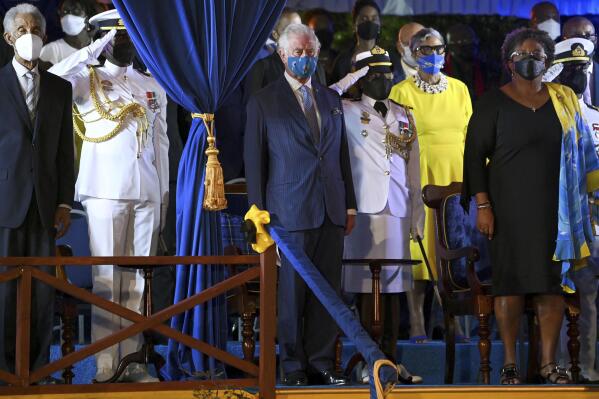Britain's Prince Charles, centre, stands with Barbados Prime Minister Mia Mottley, right, and former cricketer Garfield Sobers, left, as they attend the Presidential Inauguration Ceremony for Dame Sandra Mason, at Heroes Square, in Bridgetown, Barbados, Tuesday, Nov. 30, 2021. Barbados has stopped pledging allegiance to Queen Elizabeth II as it shed another vestige of its colonial past and became a republic for the first time in history. Several leaders, dignitaries and artists, including Prince Charles, attended a ceremony that began late Monday and stretched into Tuesday in a popular square where the statue of a well-known British lord was removed last year amid a worldwide push to erase symbols of oppression. (Jeff J Mitchell PA via AP)