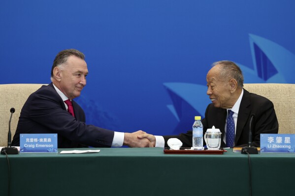 Australia's former Trade Minister Craig Emerson, left, and China's former Foreign Minister Li Zhaoxing shake hands at the 7th China-Australia High Level Dialogue at the Diaoyutai State Guesthouse in Beijing Thursday, Sept. 7, 2023. (Florence Lo/Pool Photo via AP)