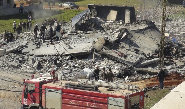 Civil defence workers and firefighters gather near a destroyed warehouse which was attacked by Israeli airstrikes, on the Hezbollah stronghold town of Safri, near Baalbek town, east Lebanon, Tuesday, March 12, 2024. A Lebanese security official and an official from the militant Hezbollah group say two Israeli airstrikes over northeastern Lebanon have killed at least two people and destroyed a warehouse. (AP Photo)