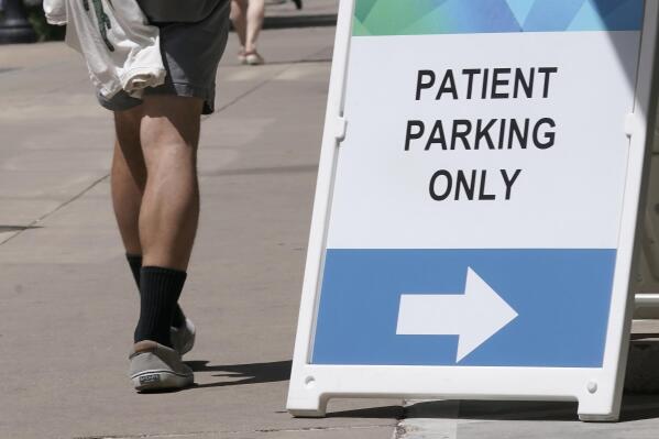 FILE— A sign directing where patients can park is displayed outside a medical facility in Sacramento, Calif., Wednesday, April 27, 2022. California lawmakers approved a bill, Thursday, May, 12, 2022, that would increase the amount of money people in California could receive who get hurt because of a doctor's negligence. (AP Photo/Rich Pedroncelli, File)