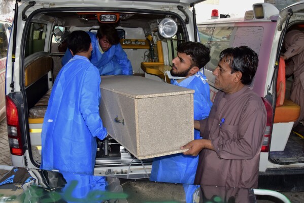Hospital staff and volunteers unload a casket from an ambulance upon arrival at a hospital in Quetta, Pakistan, Saturday, April 13, 2024. Pakistani police are searching for gunmen who killed eight people after abducting them from a bus on a highway in the country's southwest, a police official said Saturday. Earlier, the same attackers killed two people and wounded six in another car they forced to stop. (AP Photo/Arshad Butt)