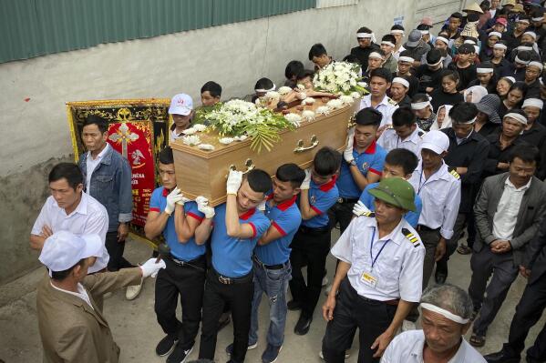 Relatives of Bui Thi Nhung walk behind her casket during a funeral procession to Phu Thang church ahead of Nhung’s burial on Sunday, Dec. 1, 2019 in the village of Do Thanh, Vietnam. The body of 19-year old Nhung was among the last remains of the 39 Vietnamese who died while being smuggled in a truck to England last month that were repatriated to their home country on Saturday. (AP Photo/Hau Dinh)