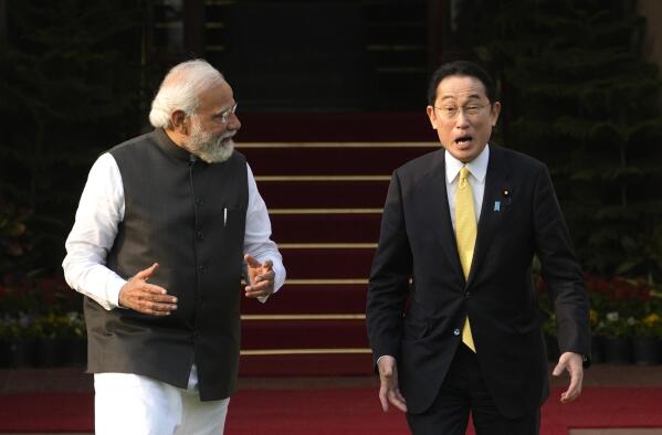 Indian Prime Minister Narendra Modi walks with his Japanese counterpart Fumio Kishida in New Delhi, Saturday, March 19, 2022. Kishida is meeting with Modi to strengthen their partnership in the Indo-Pacific and beyond in view of China’s growing footprint in the region, an Indian official said Thursday. (AP Photo/Manish Swarup)