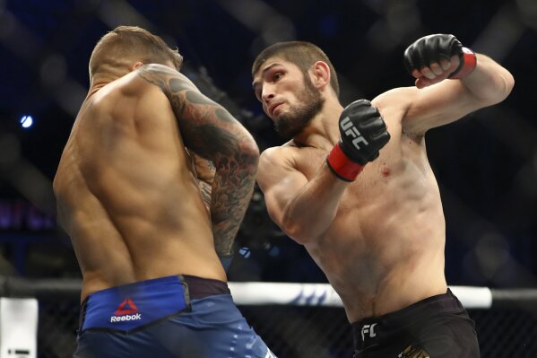 FILE - In this Sept. 7 2019, file photo, Russian UFC fighter Khabib Nurmagomedov, right, fights with UFC fighter Dustin Poirier, of Lafayette, La., during lightweight title mixed martial arts bout in Yas Mall in Abu Dhabi, United Arab Emirates. Undefeated UFC lightweight champion Khabib Nurmagomedov has agreed to return against interim champ Justin Gaethje on Oct. 24. UFC President Dana White announced the matchup Tuesday, July 28, 2020. (AP Photo/Mahmoud Khaled, File)