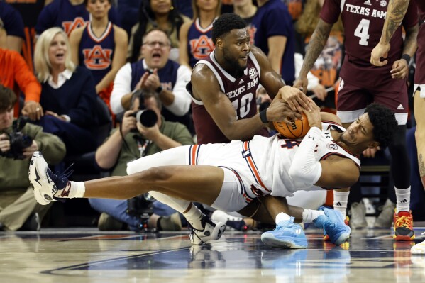 Auburn center Dylan Cardwell (44) and Texas A&M forward Wildens Leveque (10) battle for a loose ball during the first half of an NCAA college basketball game Tuesday, Jan. 9, 2024, in Auburn, Ala. (AP Photo/Butch Dill)