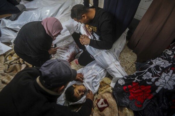 Palestinians mourn over the bodies of their relatives killed in the Israeli bombardment of the Gaza Strip at the morgue of Al Aqsa Hospital in Deir al Balah, Gaza Strip, Wednesday, April 10, 2024. (AP Photo/Ismael Abu Dayyah)