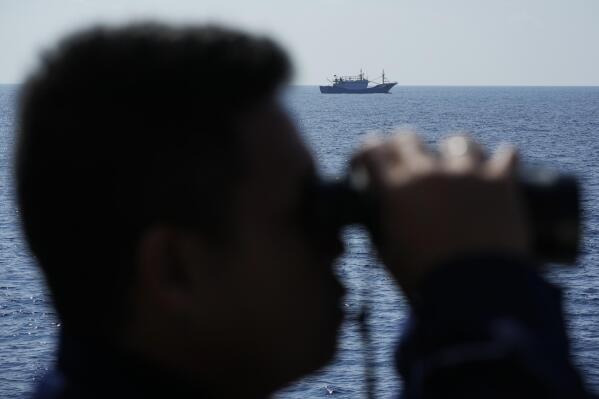 A suspected Chinese militia ship passes as members onboard the Philippine Coast Guard BRP Malabrigo drives them away from Philippine-occupied areas in the South China Sea on Friday, April 21, 2023. (AP Photo/Aaron Favila)