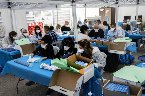 Electoral officials count ballots cast by Israelis under home quarantine after returning from Coronavirus infected zones in the city of Shoham, Israel, Wednesday, March 4, 2020. (AP Photo/Tsafrir Abayov)