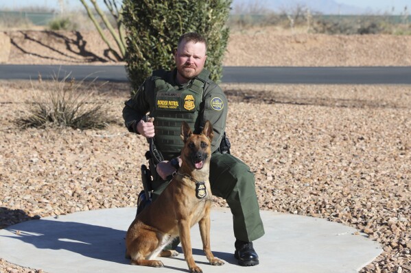 In this undated and unknown location photo released by the Department of Homeland Security shows Border Patrol Agent David Maland posing with a service dog. (Department of Homeland Security via AP, File)