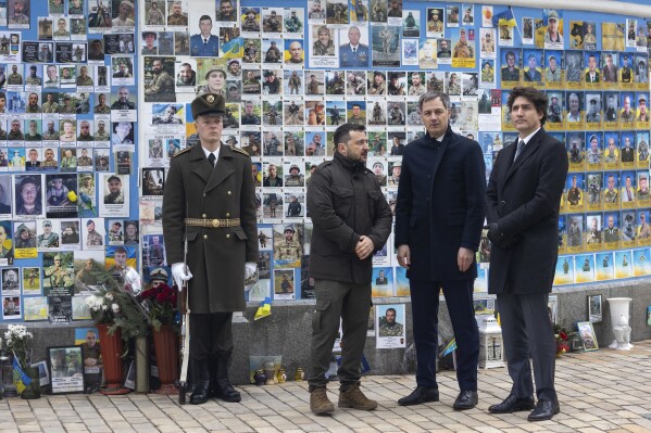 In this photo provided by the Ukrainian Presidential Press Office, Ukrainian President Volodymyr Zelenskyy, Belgian Prime Minister Alexander De Croo, centre and Canadian Prime Minister Justin Trudeau, right, speak, next to the Memory Wall of Fallen Defenders of Ukraine, in Kyiv, Ukraine, Saturday, Feb. 24, 2024. President Volodymyr Zelenskyy has welcomed Western leaders to Kyiv to mark the second anniversary of Russia's full-scale invasion, as Ukrainian forces run low on ammunition and foreign aid hangs in the balance. (Ukrainian Presidential Press Office via AP)