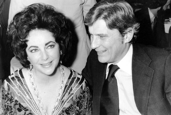 FILE - In this Jan. 30, 1977 file photo, former Secretary of the Navy and Sen. John Warner, R-Va., and his then wife, actress Elizabeth Taylor, at the 42nd New York Film Critics Circle Awards dinner in New York.  Warner, a former Navy secretary and one of the Senate’s most influential military experts, has died at 94. (AP Photo/File)
