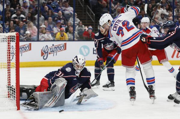 Columbus Blue Jackets' Michael Hutchinson, left, makes a save against New York Rangers' Filip Chytil during the third period of an NHL hockey game Saturday, April 8, 2023, in Columbus, Ohio. (AP Photo/Jay LaPrete)
